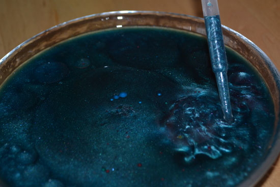 Bowl full of three kinds of colored water and oil.