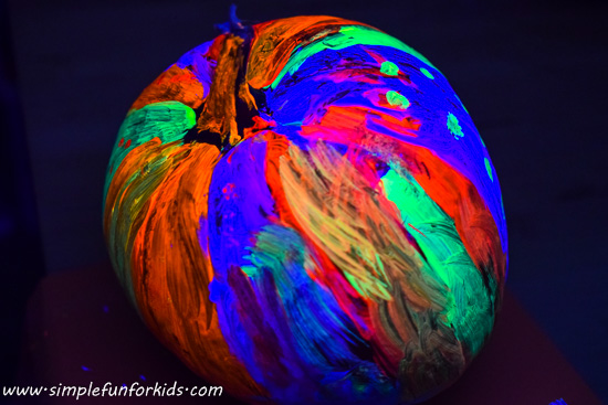 Pumpkin decoration: Make a fluorescent pumpkin with the blacklight on while painting - it looks SO COOL!