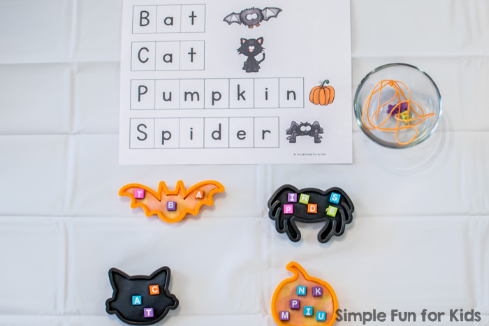 Literacy Activities for Preschoolers: Spelling Halloween words with beads and play dough! (Free printable included.)