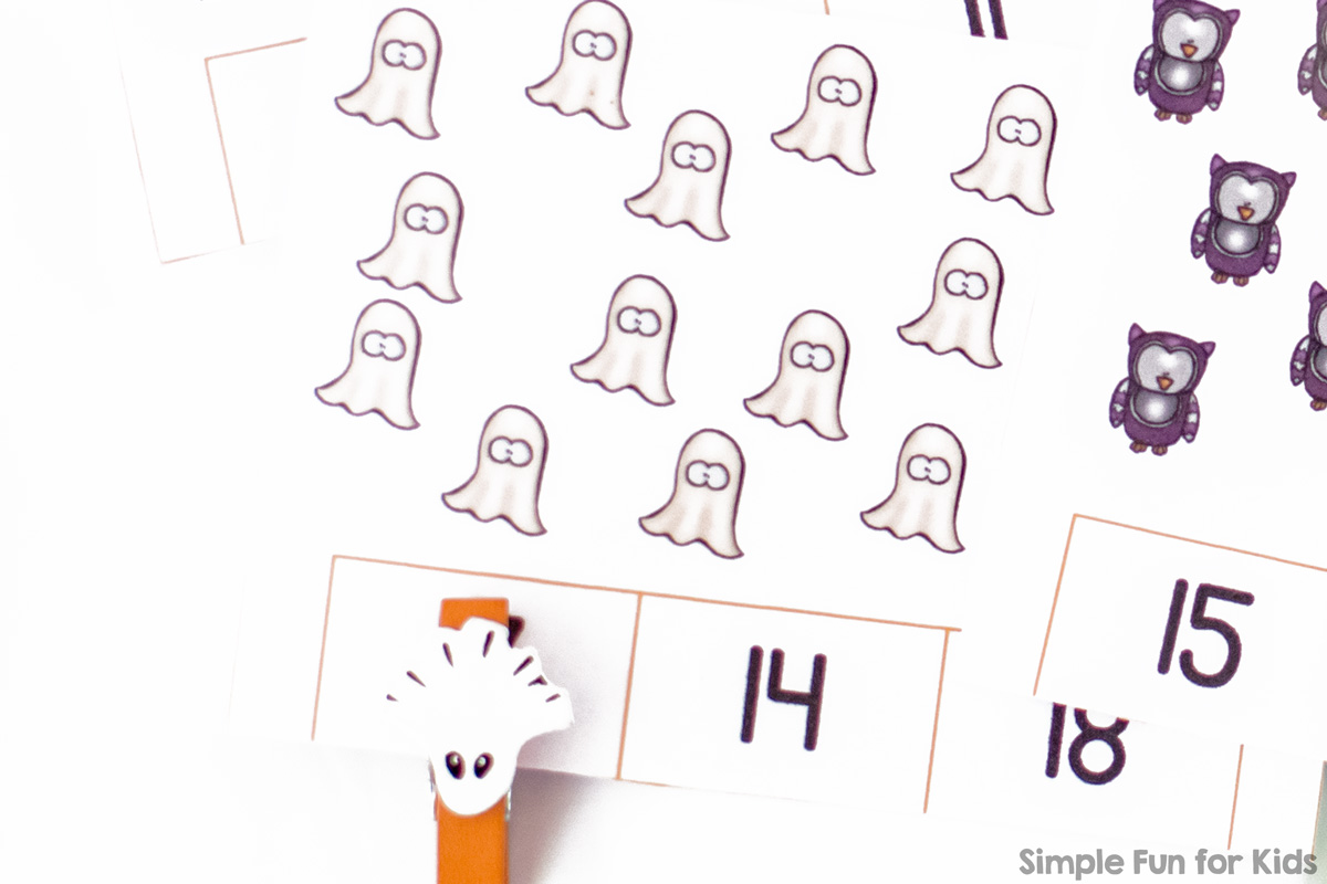 Close-up of one of the Halloween counting clip cards with pictures of cute little ghosts and a cute little ghost clothespin marking the correct number. On the right-hand side, you can see part of another clip card with owls.