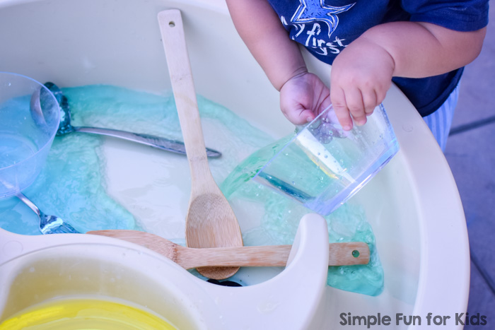Simple sibling play with water: I set up a super simple stirring, pouring, and color mixing station in the water table for my toddler, and both he and my kindergartener had great fun with it!